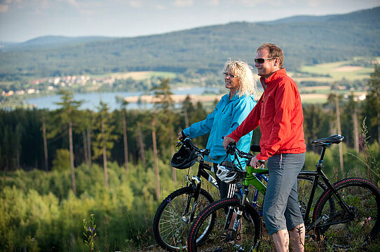 Zwei Mountainbiker stehen auf dem Waldstein und blicken in Richtung Weißenstädter See.