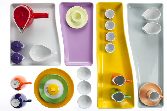 Künstlerische Anordnung von verschiedenfarbigen Tellern und Tassen aus Porzellan